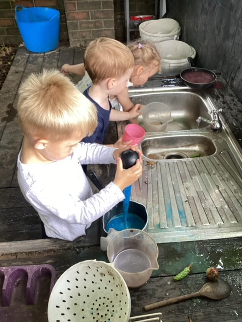 children playing in outdoor sink hocus pocus nursery